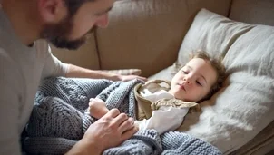 Child lying on a chair with a parent