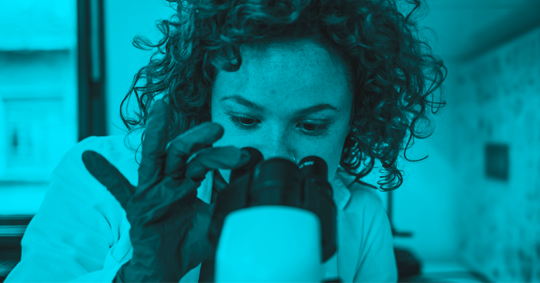 Researcher looking into a microscope