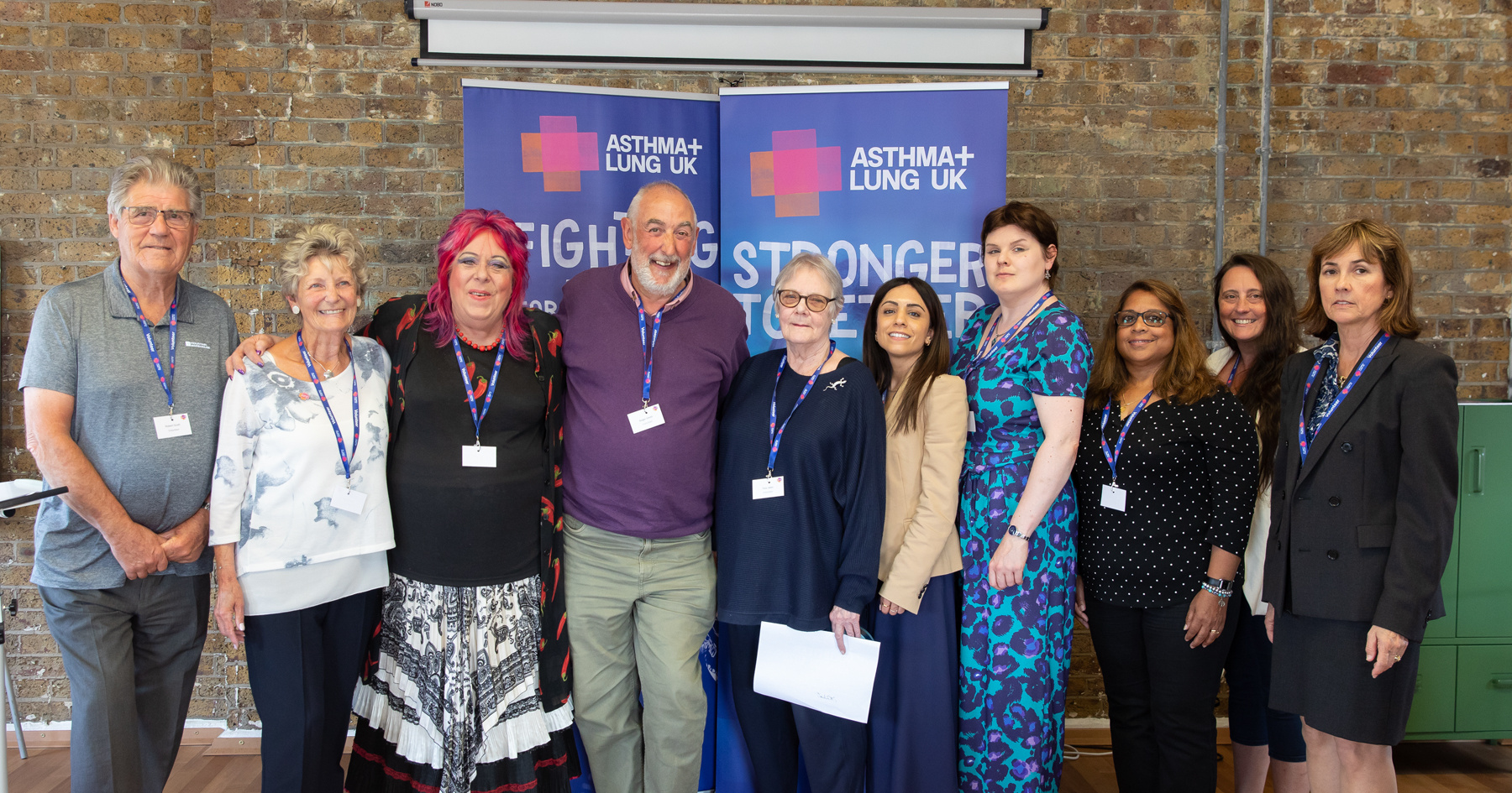 A group of people posing for a photo in front of banners for Asthma + Lung UK