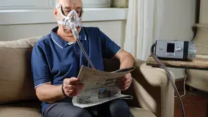 man on home ventilation reading a newspaper