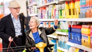 A woman in a mobility scooter doing grocery shopping with her husband