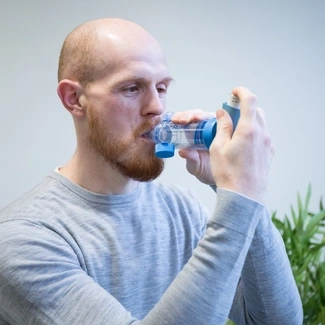 A man inhaling through an mdi inhaler