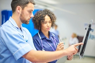 Two doctors looking at a screen in a hospital